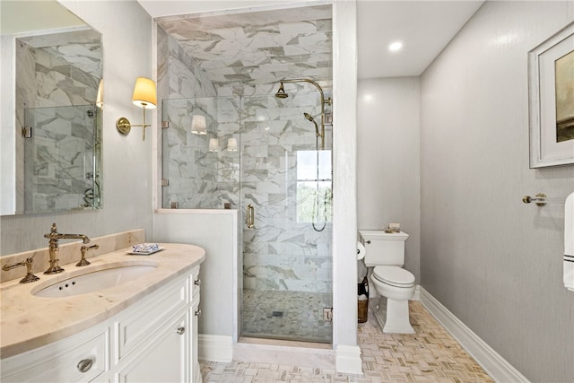 bathroom with vanity, a shower with shower door, and toilet