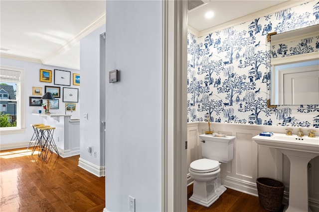 bathroom with wood-type flooring, toilet, and ornamental molding