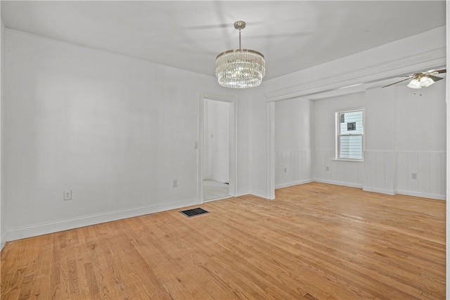 unfurnished room with ceiling fan with notable chandelier and light wood-type flooring