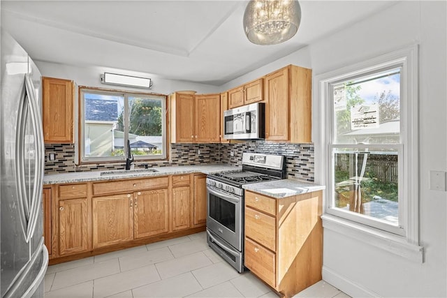 kitchen with backsplash, stainless steel appliances, a wealth of natural light, and sink