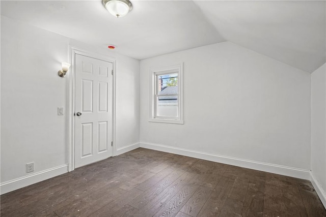 additional living space with dark wood-type flooring and vaulted ceiling