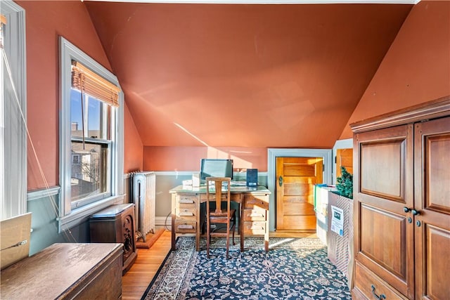 office featuring light wood-type flooring, radiator, and vaulted ceiling