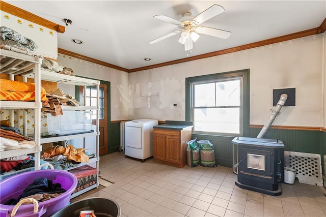 laundry room with cabinets, a wood stove, ceiling fan, and ornamental molding