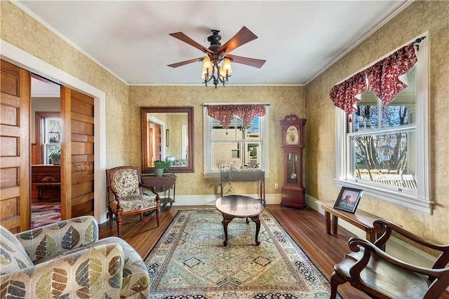 living area with wood-type flooring, crown molding, and a healthy amount of sunlight