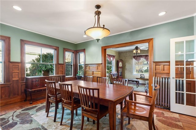 dining space with hardwood / wood-style flooring, ceiling fan, and ornamental molding