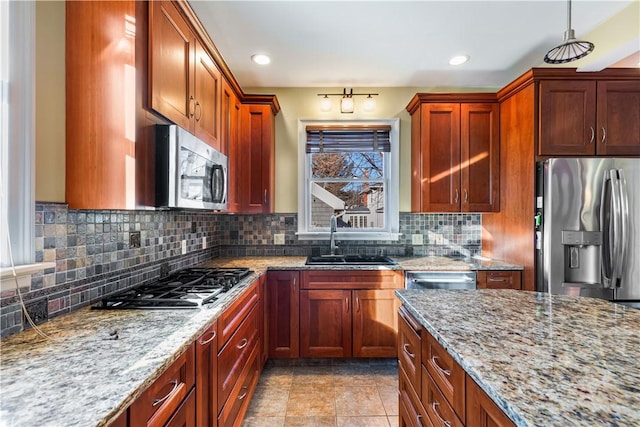 kitchen with light stone countertops, sink, decorative backsplash, light tile patterned floors, and appliances with stainless steel finishes