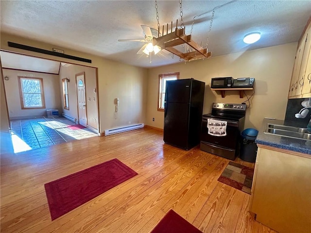 kitchen featuring black appliances, sink, a textured ceiling, a baseboard radiator, and light hardwood / wood-style floors