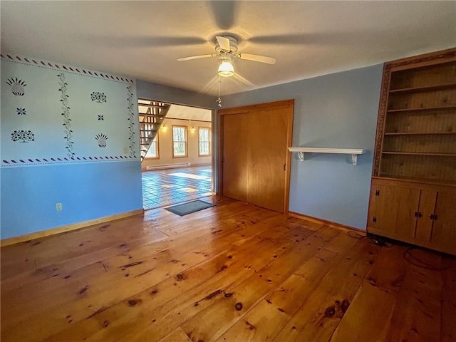 interior space with ceiling fan and wood-type flooring