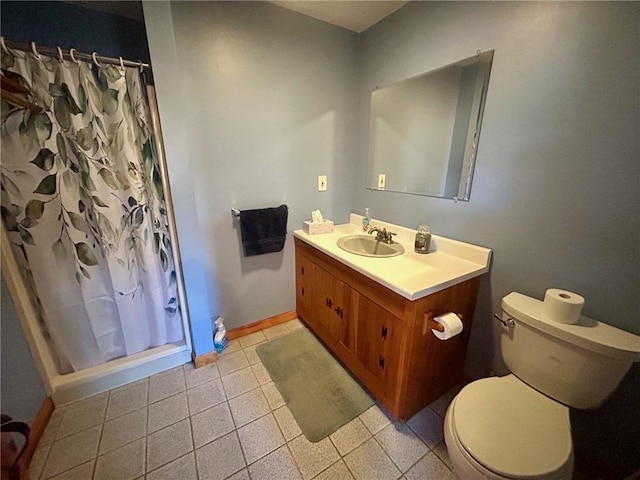 bathroom with tile patterned floors, curtained shower, vanity, and toilet