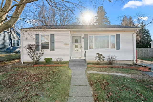 bungalow-style home with a front lawn