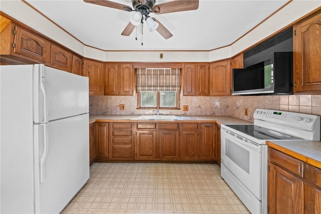 kitchen with backsplash, ceiling fan, sink, and white appliances