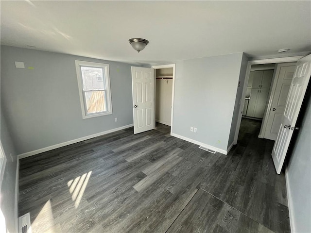 unfurnished bedroom featuring a closet and dark wood-type flooring