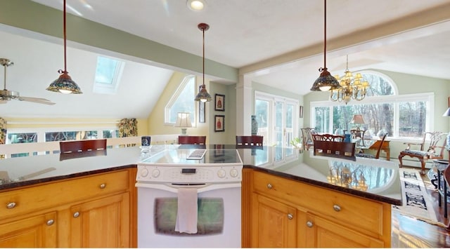 kitchen featuring ceiling fan with notable chandelier, white range with electric stovetop, vaulted ceiling with skylight, and hanging light fixtures