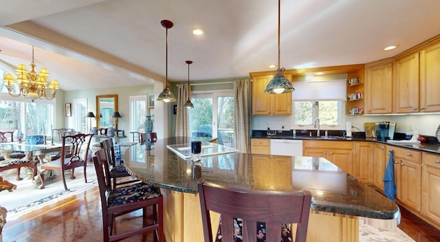 kitchen with hanging light fixtures, a notable chandelier, a kitchen breakfast bar, and a center island