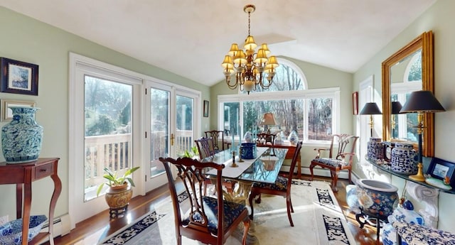 sunroom / solarium featuring lofted ceiling, an inviting chandelier, and a baseboard radiator