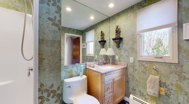 bathroom featuring toilet, baseboard heating, a wealth of natural light, and vanity