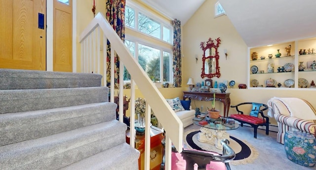 stairway featuring built in shelves, lofted ceiling, and carpet floors