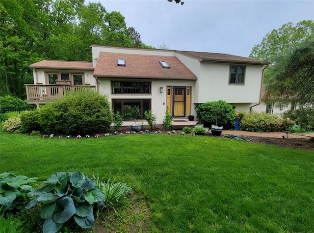 view of front of property featuring a deck and a front lawn