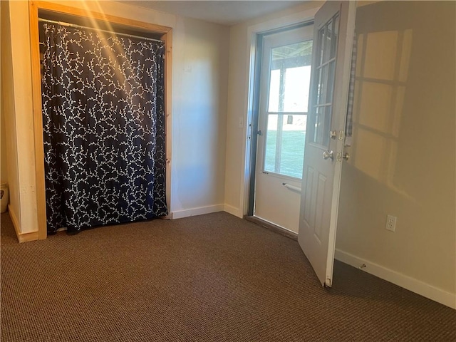 doorway with dark colored carpet