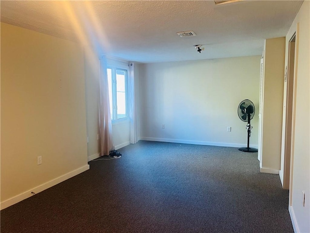 unfurnished room with a textured ceiling