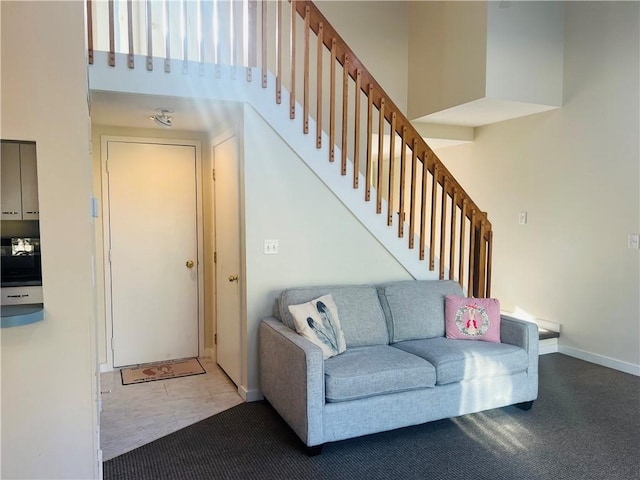 carpeted living room with a high ceiling