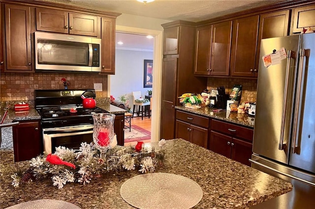 kitchen with backsplash, dark stone countertops, and stainless steel appliances