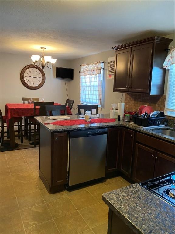 kitchen with a peninsula, dark brown cabinetry, a sink, and stainless steel dishwasher