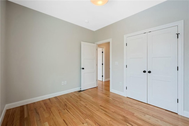 unfurnished bedroom featuring light hardwood / wood-style floors and a closet