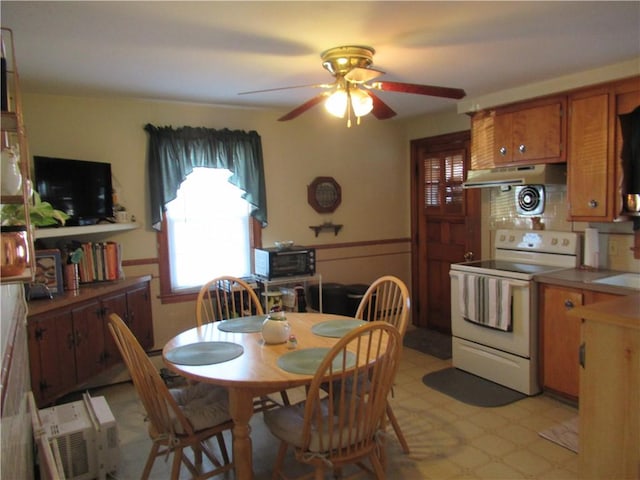 dining space featuring ceiling fan and sink