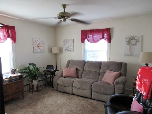 carpeted living room featuring a baseboard heating unit and ceiling fan