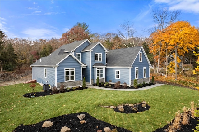 view of front of property with central AC and a front yard