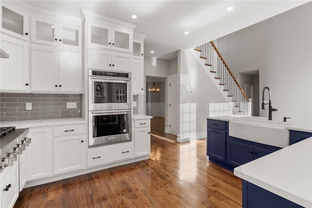 kitchen with stainless steel double oven and white cabinetry