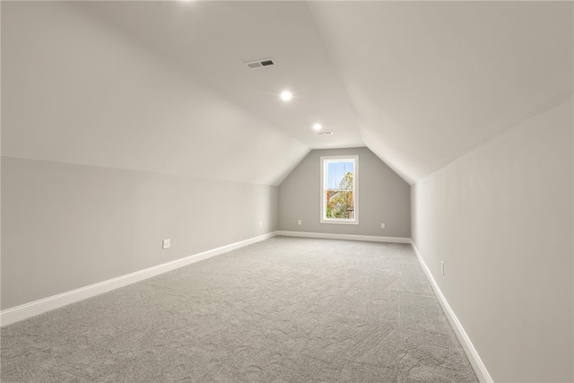 additional living space with light colored carpet and lofted ceiling