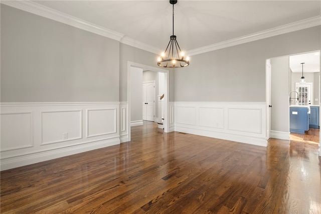 empty room with a notable chandelier, ornamental molding, and dark wood-type flooring