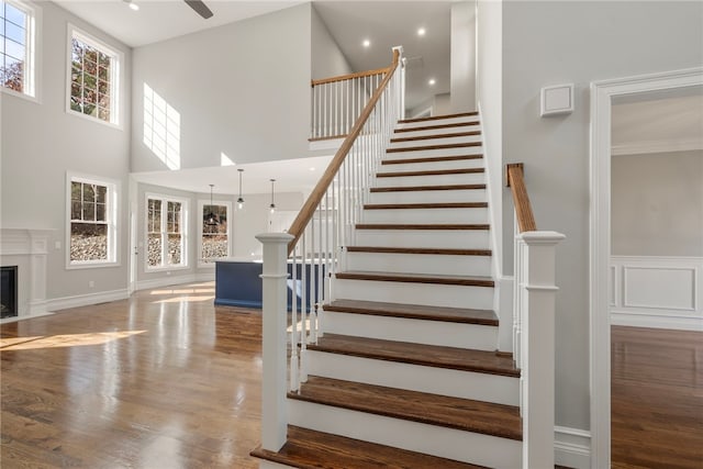 stairway with hardwood / wood-style floors and a high ceiling