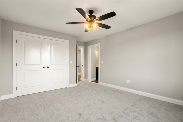 unfurnished bedroom featuring light colored carpet, a closet, and ceiling fan