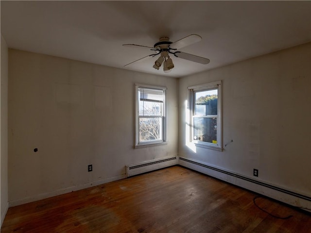 spare room featuring hardwood / wood-style flooring, ceiling fan, and a baseboard heating unit