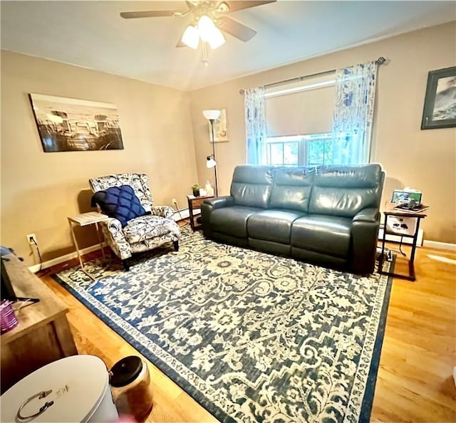 living room with hardwood / wood-style flooring, ceiling fan, and baseboard heating