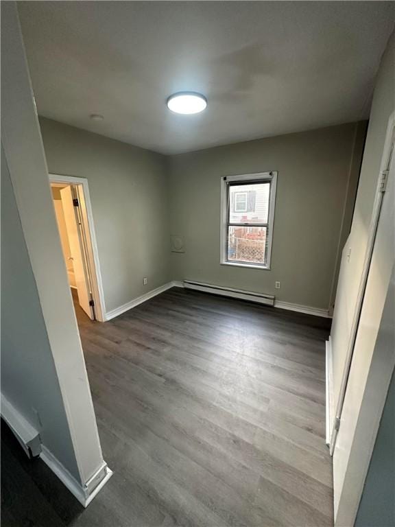 unfurnished bedroom featuring dark wood-type flooring and a baseboard radiator