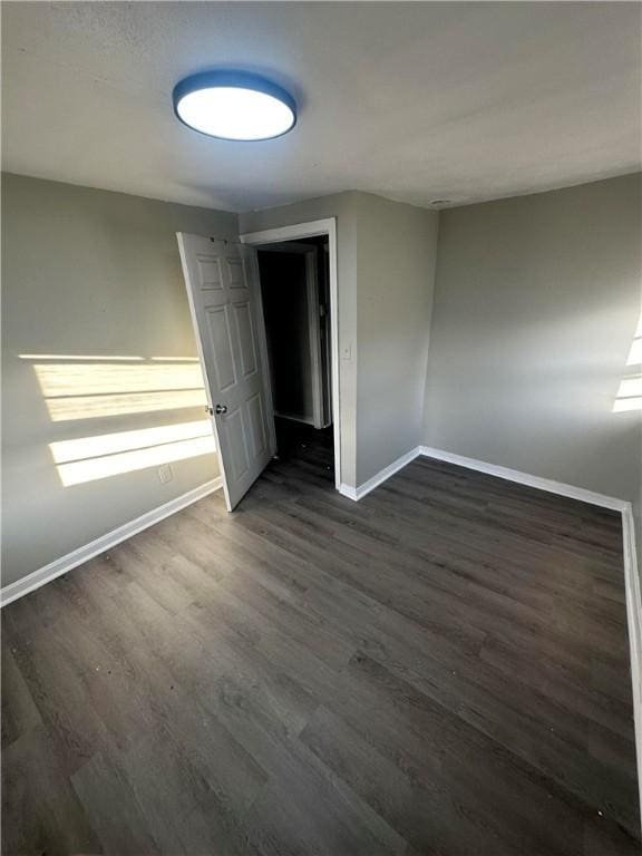 unfurnished bedroom with dark hardwood / wood-style flooring and a closet