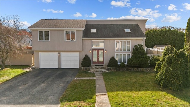 view of front of property featuring french doors, a front yard, and a garage