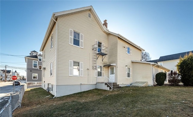 rear view of property featuring a lawn