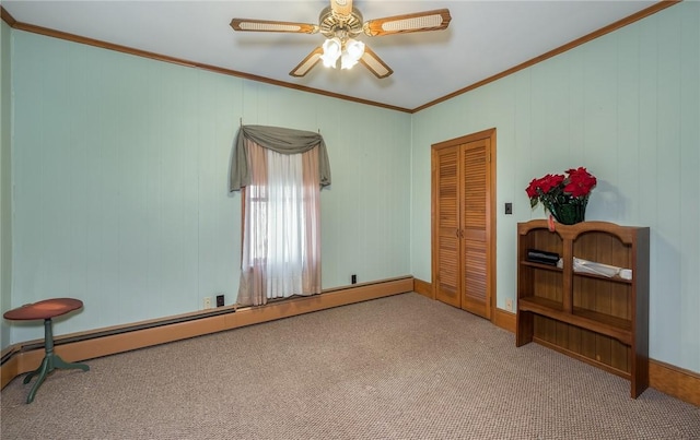 carpeted empty room with a baseboard heating unit, ceiling fan, and ornamental molding