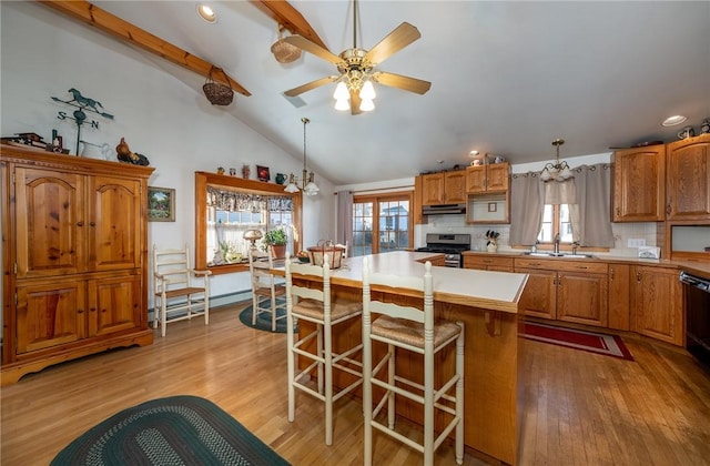 kitchen featuring hanging light fixtures, backsplash, and stainless steel stove