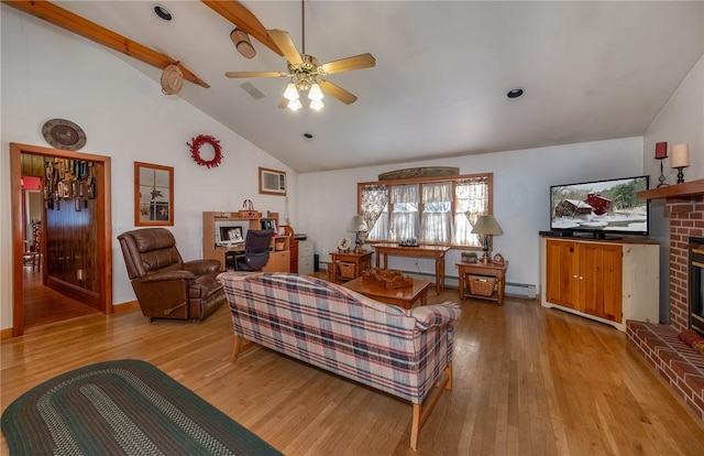 living room featuring a baseboard heating unit, beamed ceiling, a fireplace, light wood-type flooring, and ceiling fan