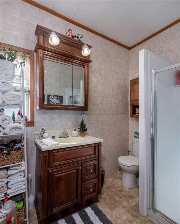 bathroom featuring a shower with door, vanity, tile walls, toilet, and crown molding