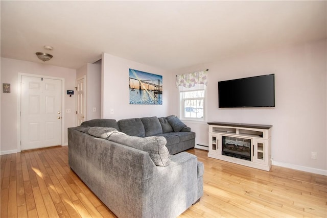 living room with light wood-type flooring and a baseboard heating unit