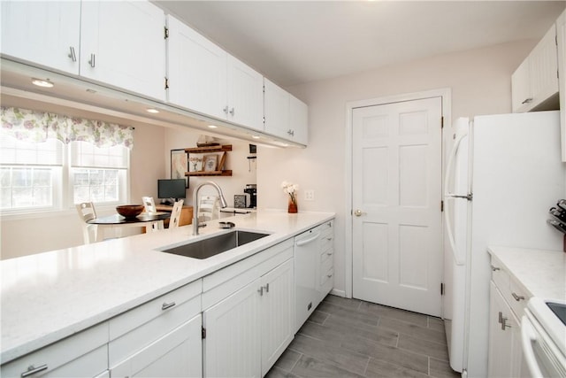 kitchen with sink, white appliances, and white cabinetry