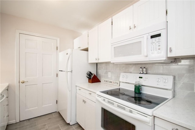 kitchen with white cabinetry, white appliances, and tasteful backsplash