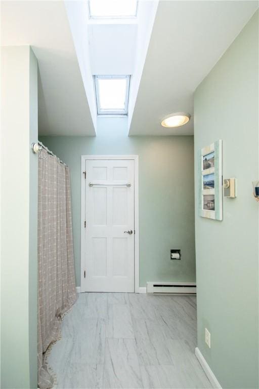 bathroom featuring a baseboard heating unit and a skylight